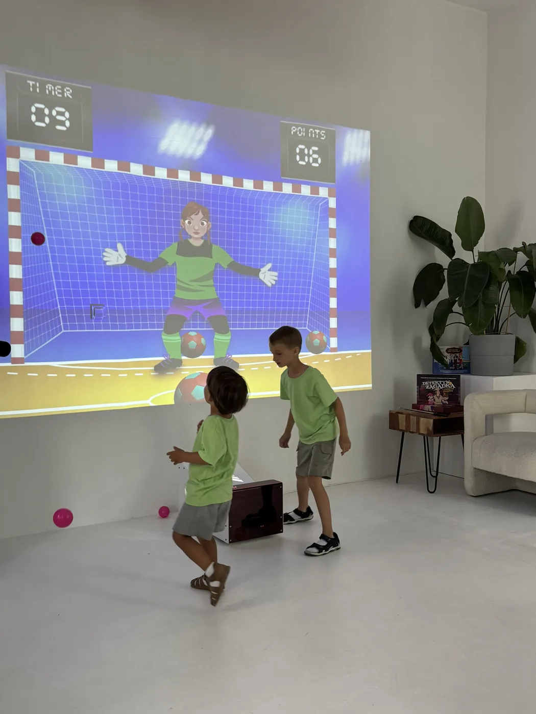 Kinder spielen mit Bällen an der interaktiven Wunderplay Wandprojektion
